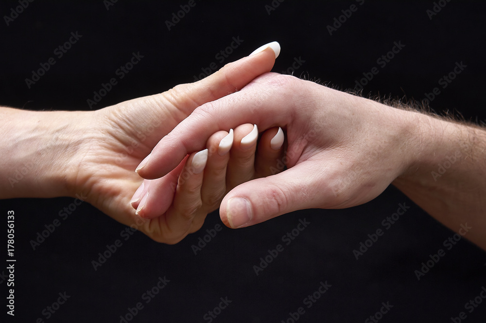 Male and female hands together on black background Male and female hands together on black background