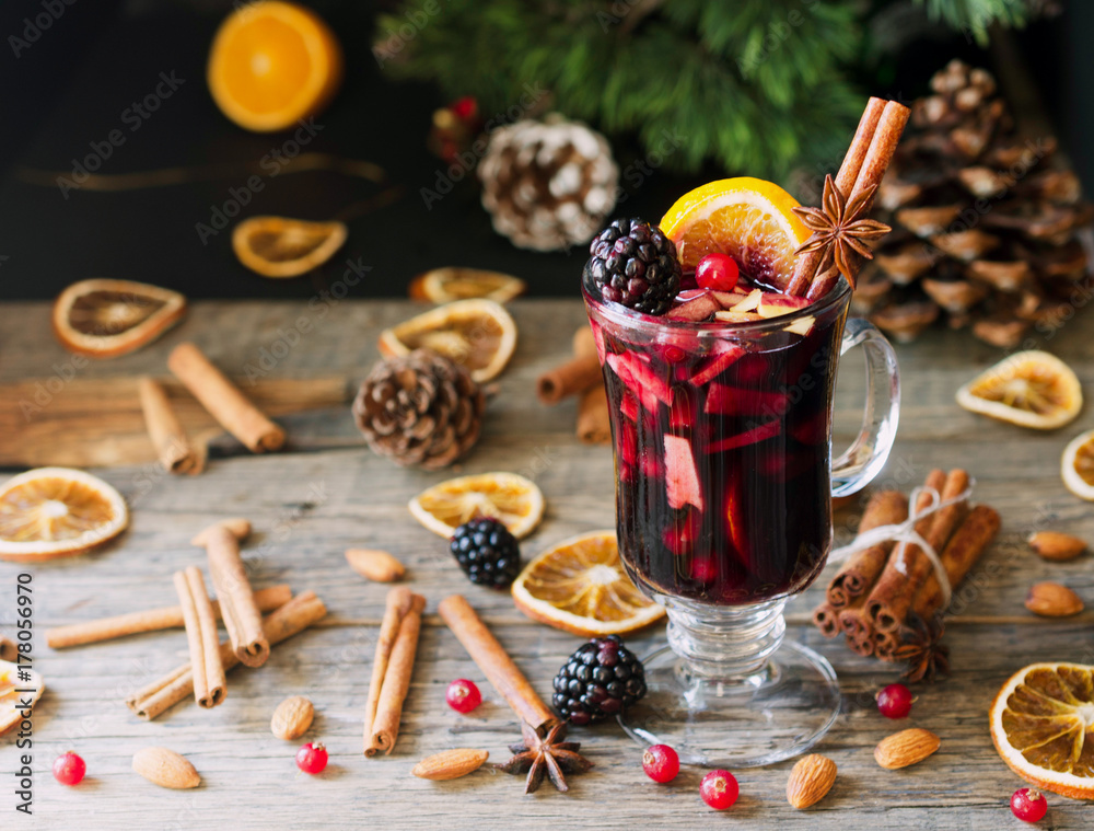 glass of hot mulled wine for the new year with ingredients for cooking, nuts and Christmas decorations glass of hot mulled wine for the new year with ingredients for cooking, nuts and Christmas decorations