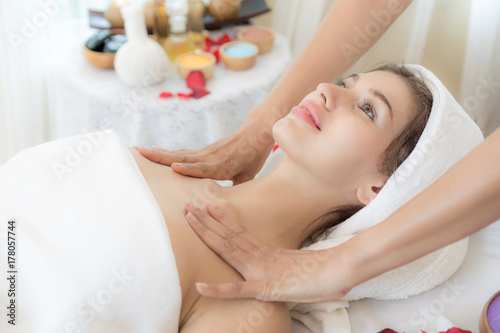 beautiful and healthy young woman relaxing with face massage at beauty spa salon