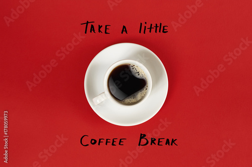 Top view of cup of black coffee and Take a little coffee break lettering isolated on red background