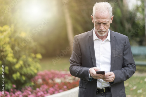 Mature man using his mobile phone, light effect