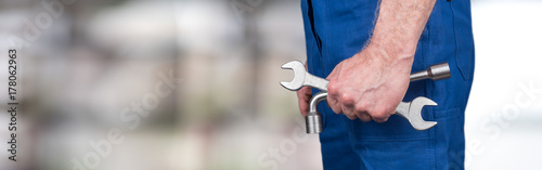 Hand of mechanic holding wrenches