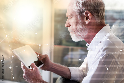 Senior businessman using a digital tablet, light effect, overlayed with network