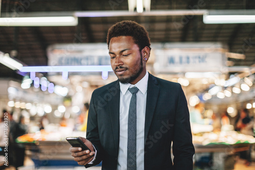 African american businessman using mobile phone on a market. photo