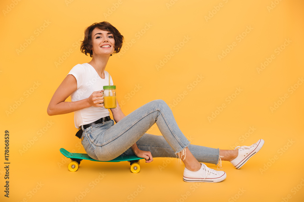 Portrait of a pretty cute girl sitting on a skateboard Portrait of a pretty cute girl sitting on a skateboard