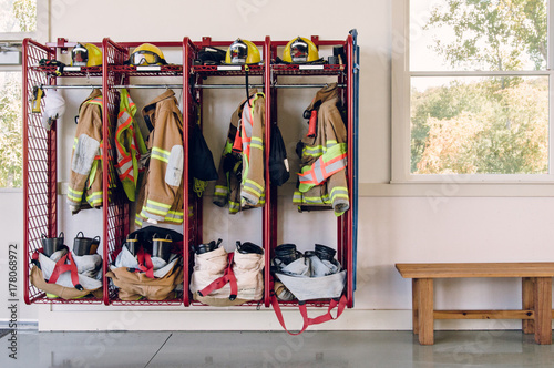 firefighters' uniforms inside a firehouse photo