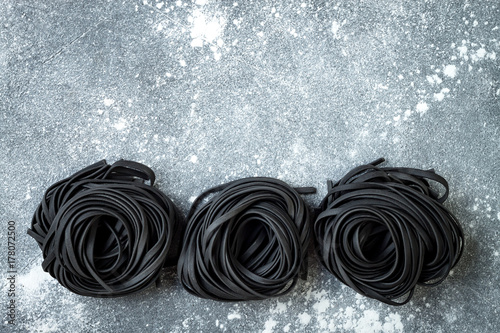 Fényképezés Detox charcoal or black squid ink fettuccine on grey background