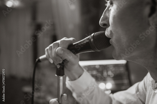 Man with a microphone close-up. Black and white photo. A close-up of a singing man.