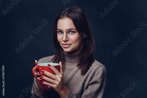 A woman holds the red coffee cup.