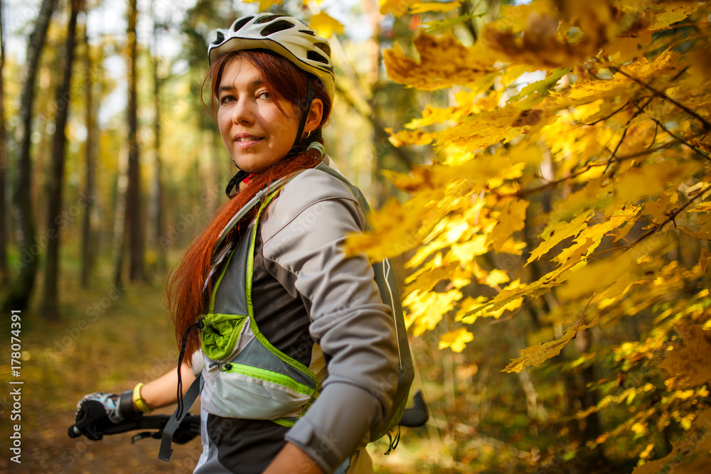 Photo of girl in helmet on bicycle in autumn forest Photo of girl in helmet on bicycle in autumn forest