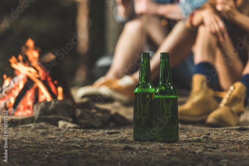 Valokuvatapetti bottles of beer next to bonfire