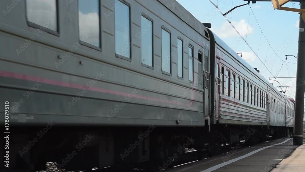 Passenger train passing by the platform in small town Passenger train passing by the platform in small town