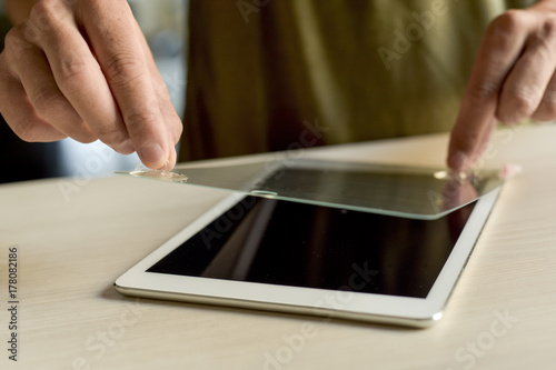 Εκτύπωση καμβά man installing a screen protector in a tablet