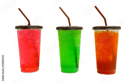 isolated on white background. iced red soda, green soda and lemon tea in transparent plastic glass with brown lid and straw bend to left.