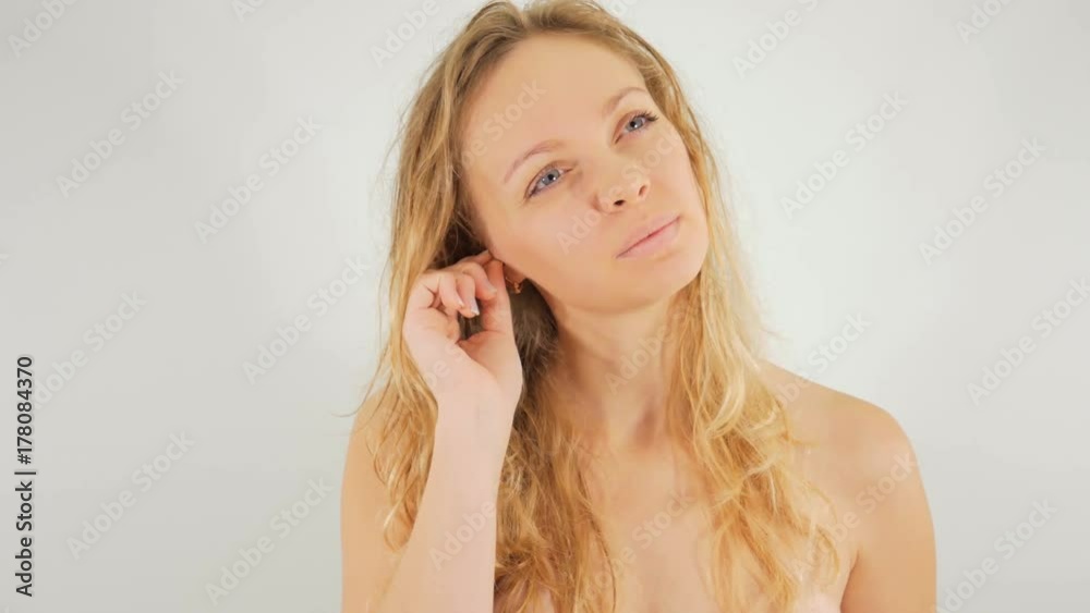 4k Girl brushing her ears in front of the mirror . Isolated on white background. 4k Girl brushing her ears in front of the mirror . Isolated on white background.