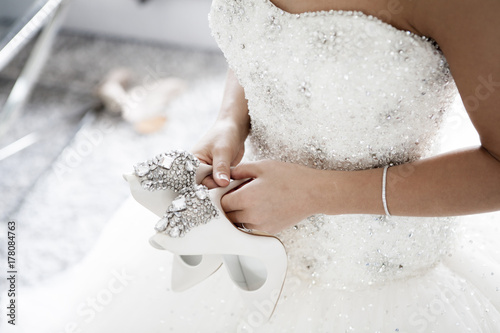 Woman holding her wedding shoes
