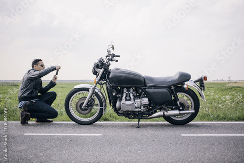 Motorcyclist taking photo of his motor