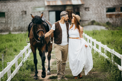 Beautiful couple with horse in the stables