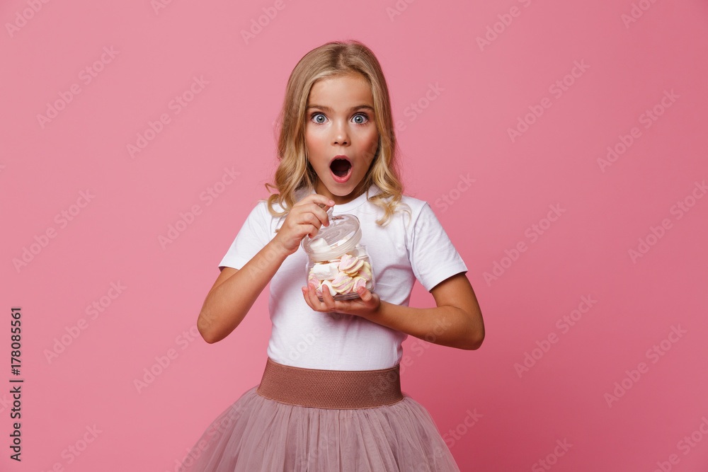 Portrait of an excited little girl holding jar of marshmallow Portrait of an excited little girl holding jar of marshmallow