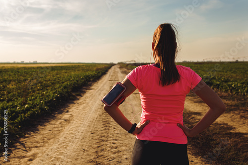 Athletic woman preparing run on dirt road.