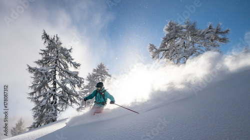 A snow covered skier races down an off-piste area in the Zauchensee ski region, Austria. photo