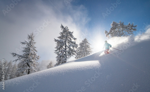 A snow covered skier races down in an off-piste area in the Zauchensee ski region, Austria. photo