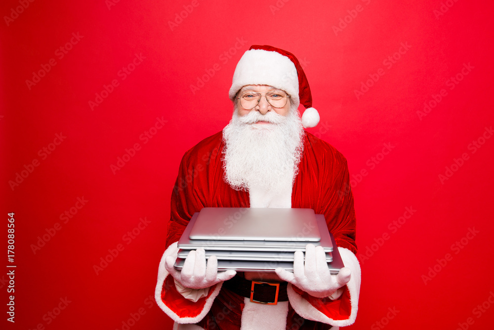 Fototapeta premium Discount, marketing, sales, advertisement, presents, gifts selling concept. Holly jolly x mas, noel is soon! Cheerful saint nicholas holding gadgets, isolated on red background