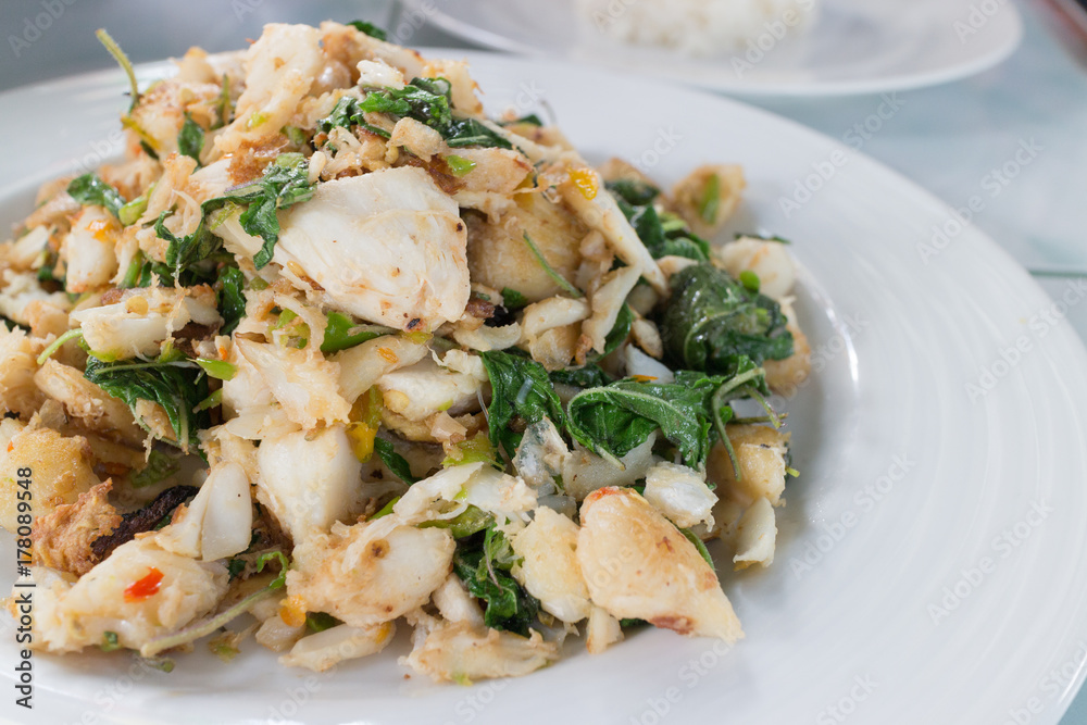 stir fry spicy crab with basil and chili on white dish, closeup shot stir fry spicy crab with basil and chili on white dish, closeup shot