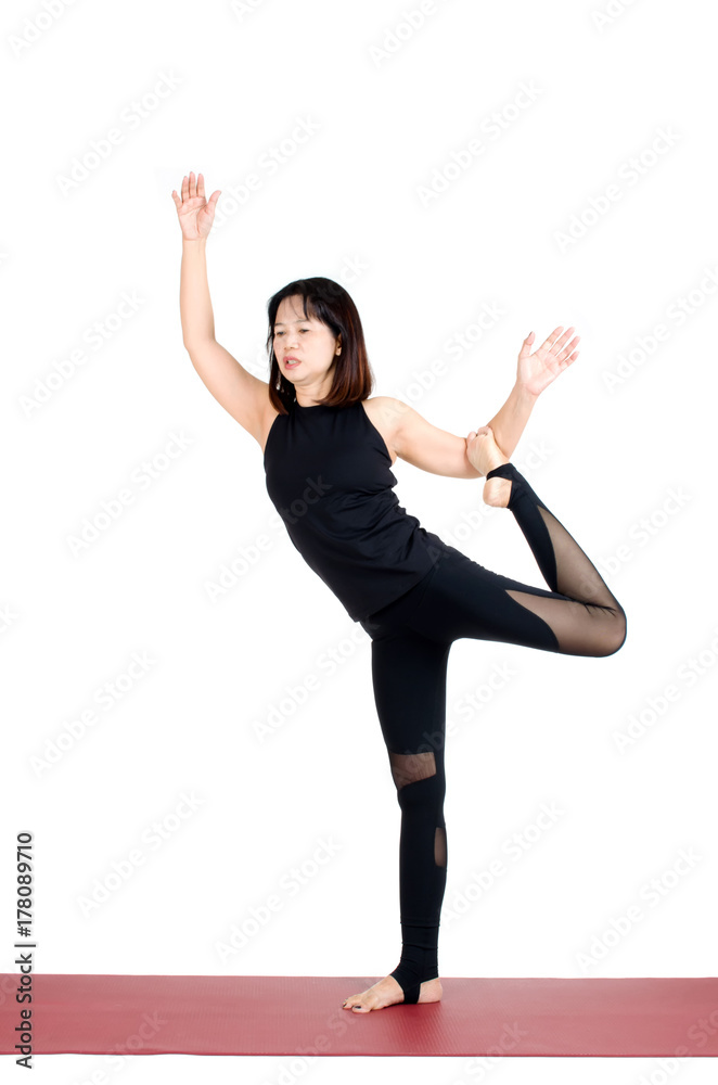 middle aged asian woman doing yoga in Natarajasana or Lord of the Dance Pose yoga pose on the mat isolated on white background, exercise fitness, sport training, healthy lifestyle and people concept