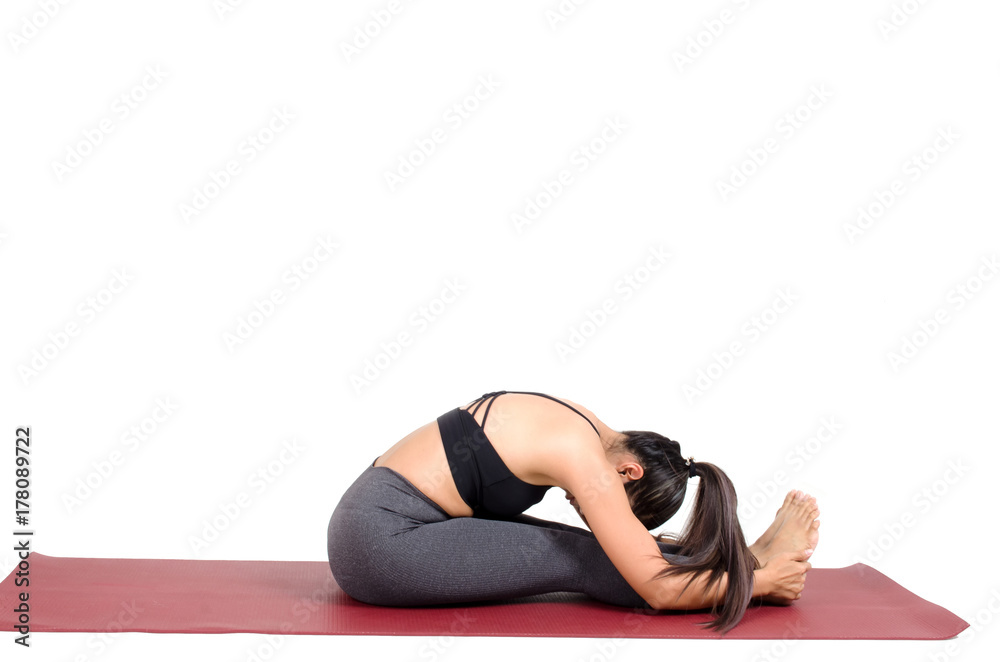 young asian woman doing yoga in Paschimottanasana yoga pose on the mat isolated on white background, exercise fitness, sport training, healthy lifestyle and people concept