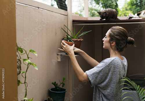 Woman at home with plants and cats