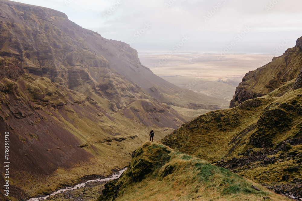 Naklejka premium An Adventure Hiker in an Iceland Canyon Wide View of the Landscape