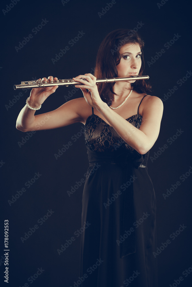 Woman playing transverse flute on black. Woman playing transverse flute on black.
