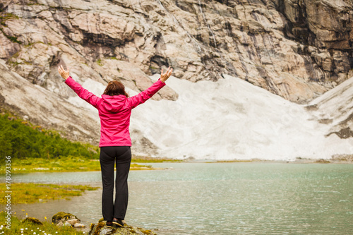 Woman with raised hands in norwegian mountains