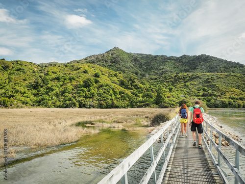 Two backpackers are walking into the Abel Tasman Coast Track in the South Island, New Zealand. photo