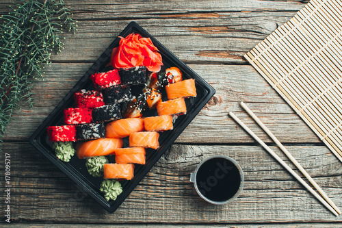 on a wooden table lay in the black sushi container photo