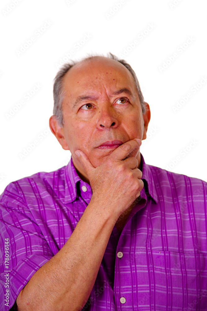 Portrait of a mature man, with his hand in his cheek thinking, wearing a purple square t-shirt in a white background Portrait of a mature man, with his hand in his cheek thinking, wearing a purple square t-shirt in a white background