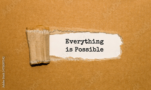 The text Everything is Possible appearing behind torn brown paper photo