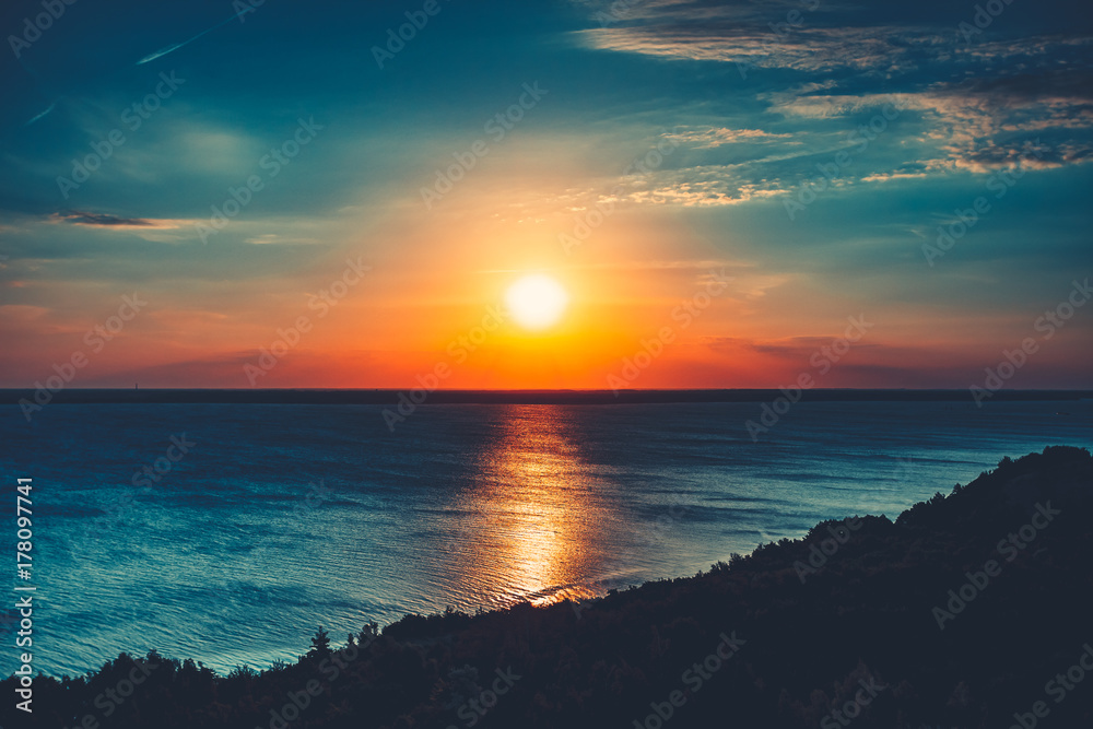 Sunset sky background. Natural Sunset Sunrise Over Ocean. Bright Dramatic Sky And Blue Water. Colorful Nature Landscape