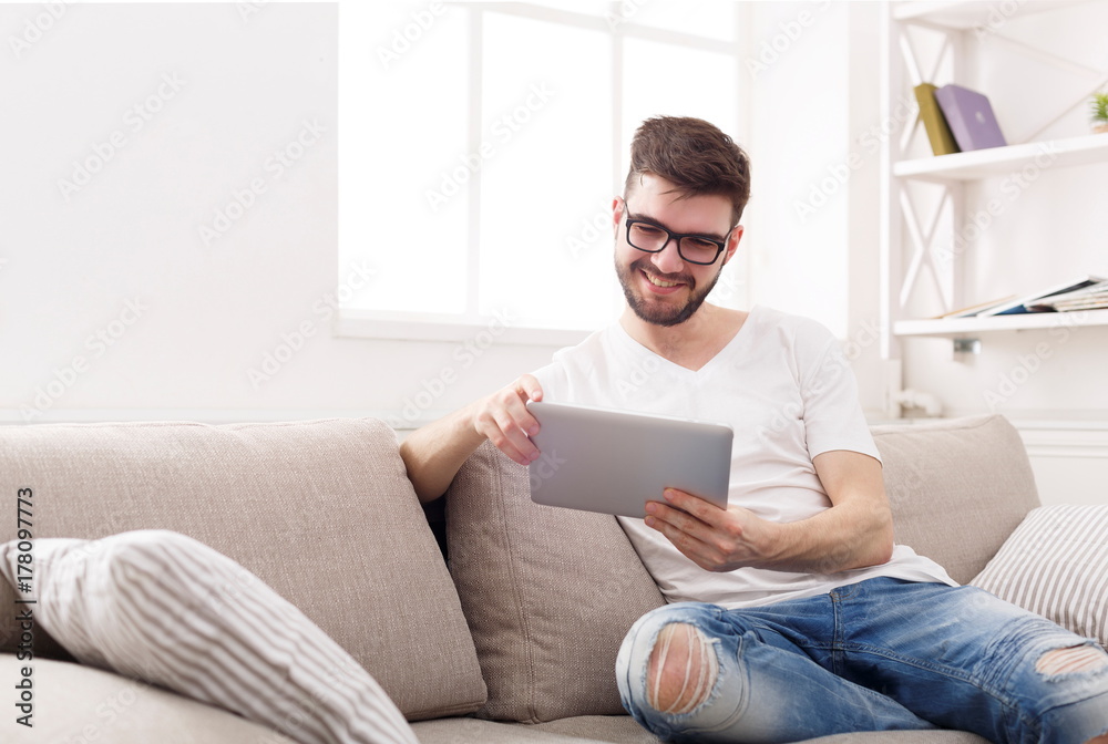 Young man at home reading on tablet Young man at home reading on tablet