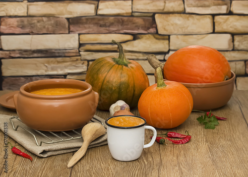 A bright cream soup of pumpkin on a wooden table.