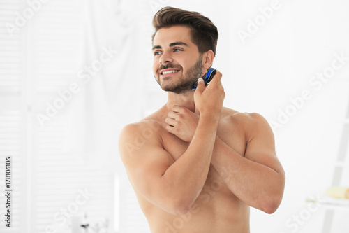 Handsome young man shaving ...