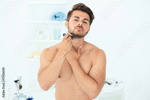 Handsome young man shaving ...
