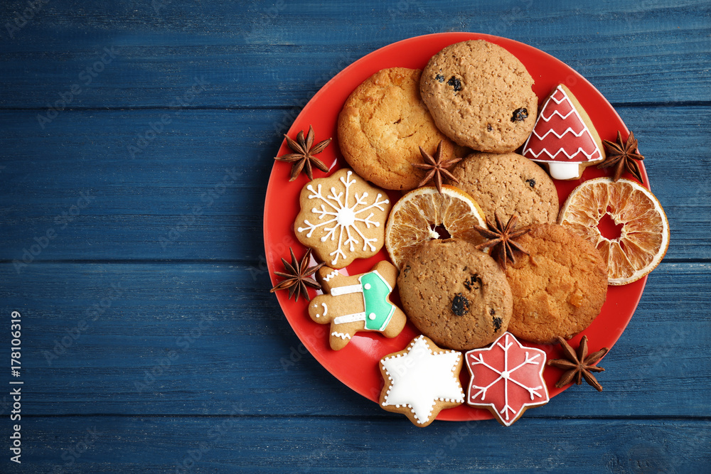 Plate with delicious Christmas cookies on wooden background
