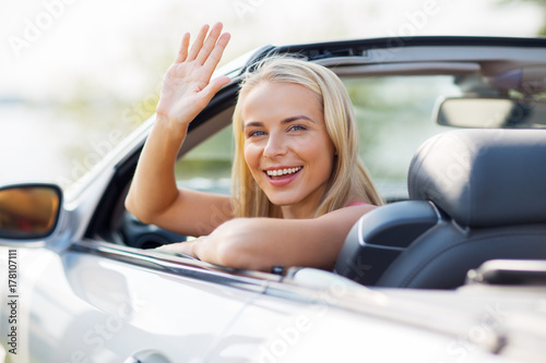 happy young woman in convertible car waving hand © Syda Productions
