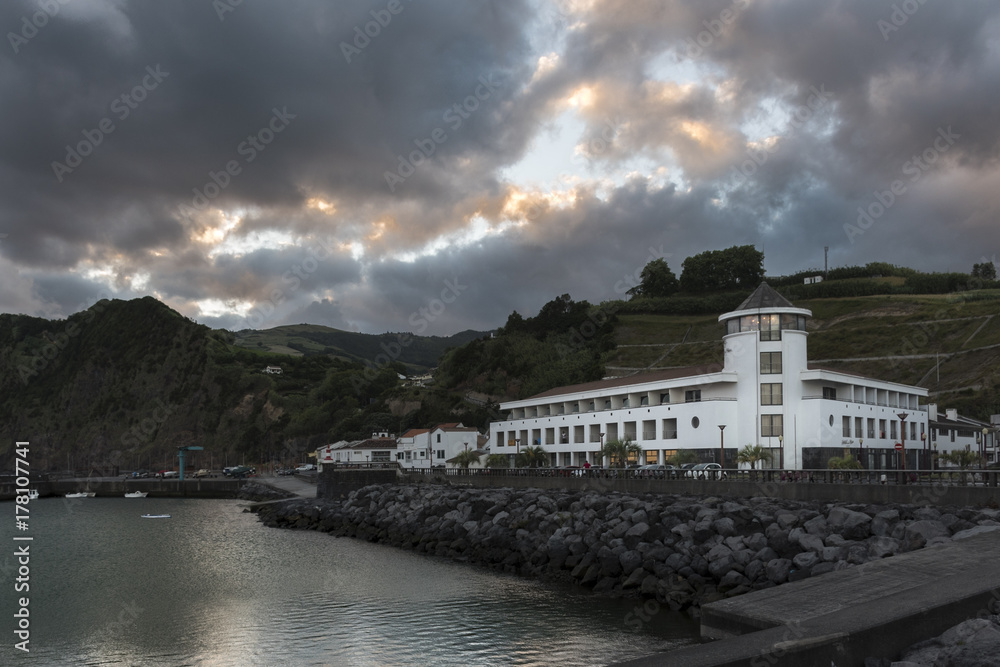 Sunset from the jetty and as a main sight a lighthouse turned into a hotel. Island of Azores