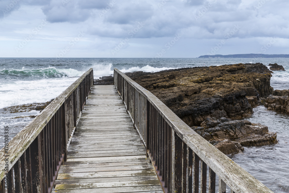 Wooden footbridge on the coast of Northern Ireland in a cloudy day Wooden footbridge on the coast of Northern Ireland in a cloudy day