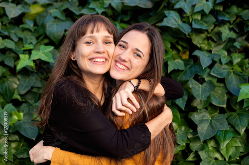 Outdoor portrait of two happy sisters in a park photo