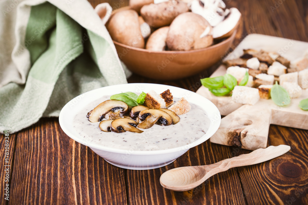 Hot homemade mushroom soup and bowl with fresh raw mushrooms Hot homemade mushroom soup and bowl with fresh raw mushrooms