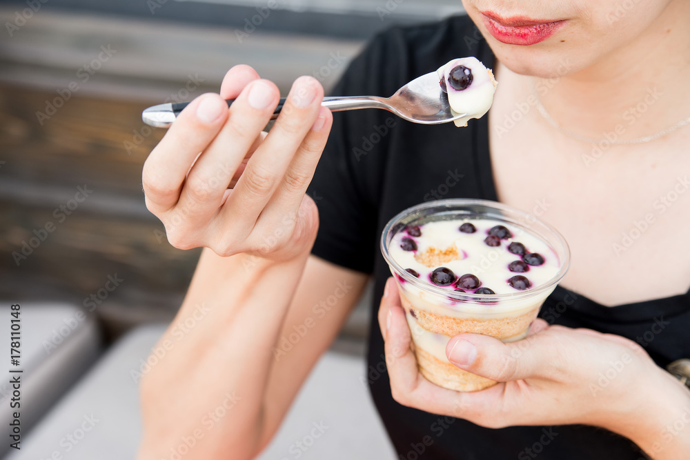 Woman eats dessert with blueberries in restaurant Woman eats dessert with blueberries in restaurant